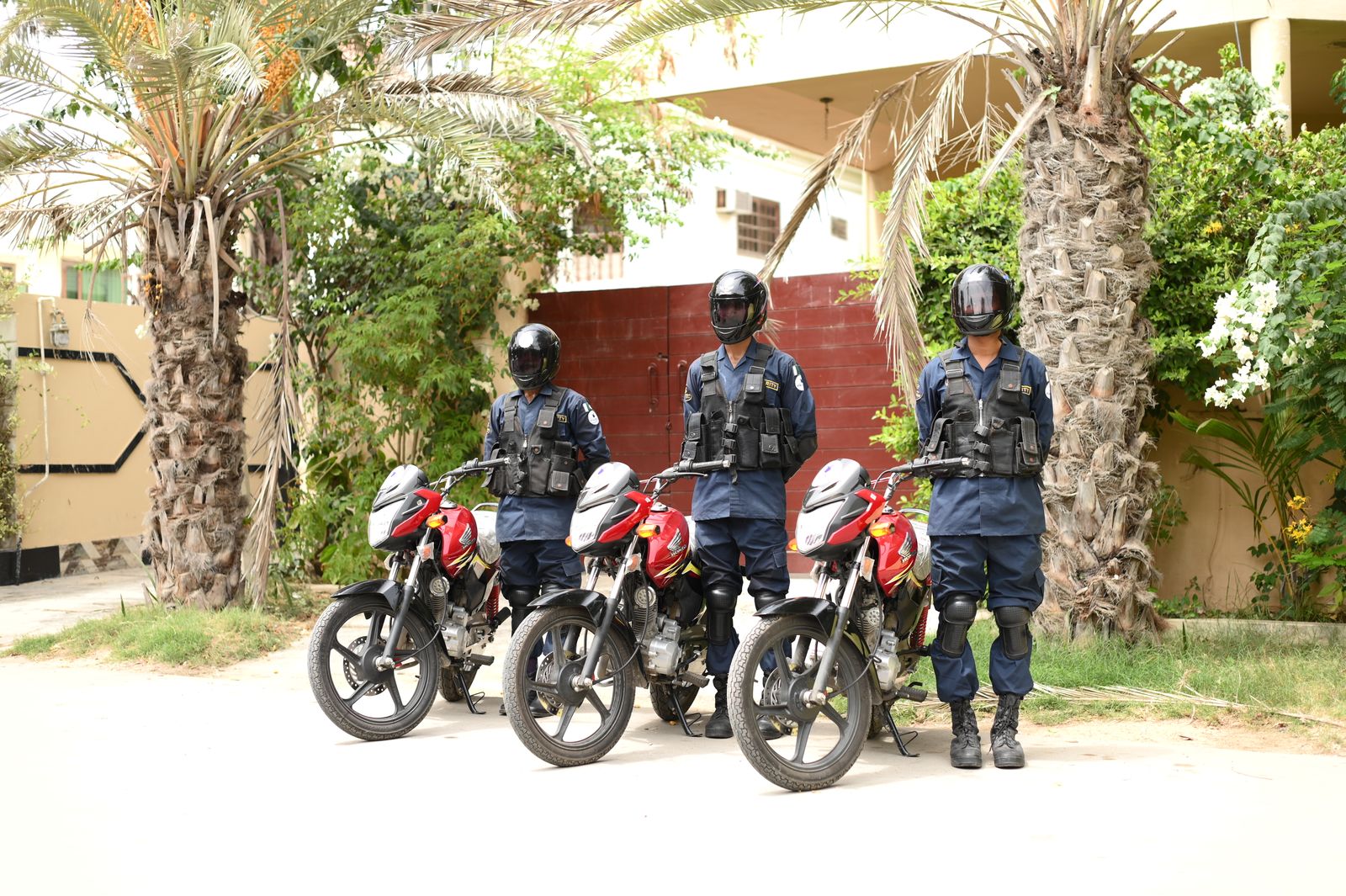 Three uniformed security officers with patrol motorcycles
